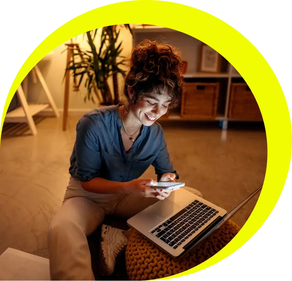 woman sitting on floor using laptop and phone